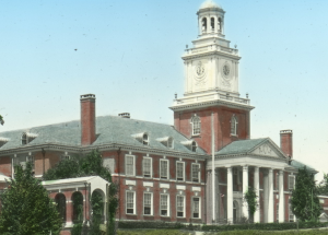 Colorized photo of Gilman Hall, showing its top two floors and columned entrance and clock tower.