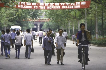 Photos of people in China walking down a street with Banners red banners overhead.