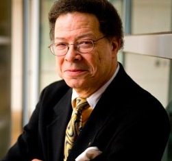 Portrait photo of Levi Watkins, Jr. with a small fro, wearing glasses, and a suit and tie.