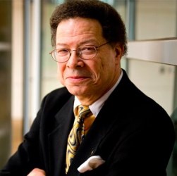 Portrait photo of Levi Watkins, Jr. with a small fro, wearing glasses, and a suit and tie.