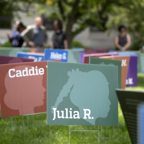 Several yard signs designed with profile silhouettes of Back girls and their names.