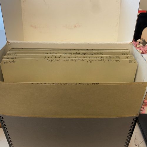 An archival box with several labeled folders sits open