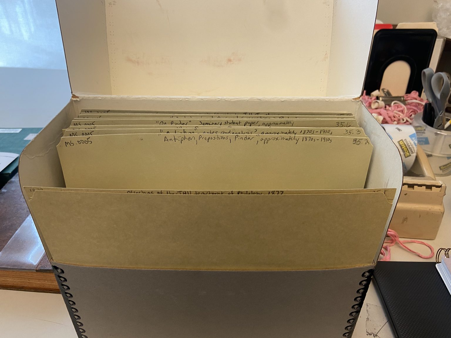 An archival box with several labeled folders sits open