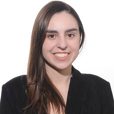 Headshot of a young woman wearing a black blaze and patterned blouse.